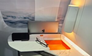 a desk with a laptop and a phone and a lamp