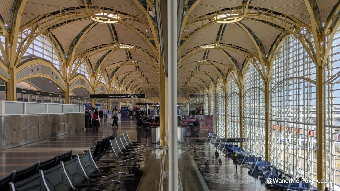 yellow arched ceiling of an airport terminal split by a vertical line