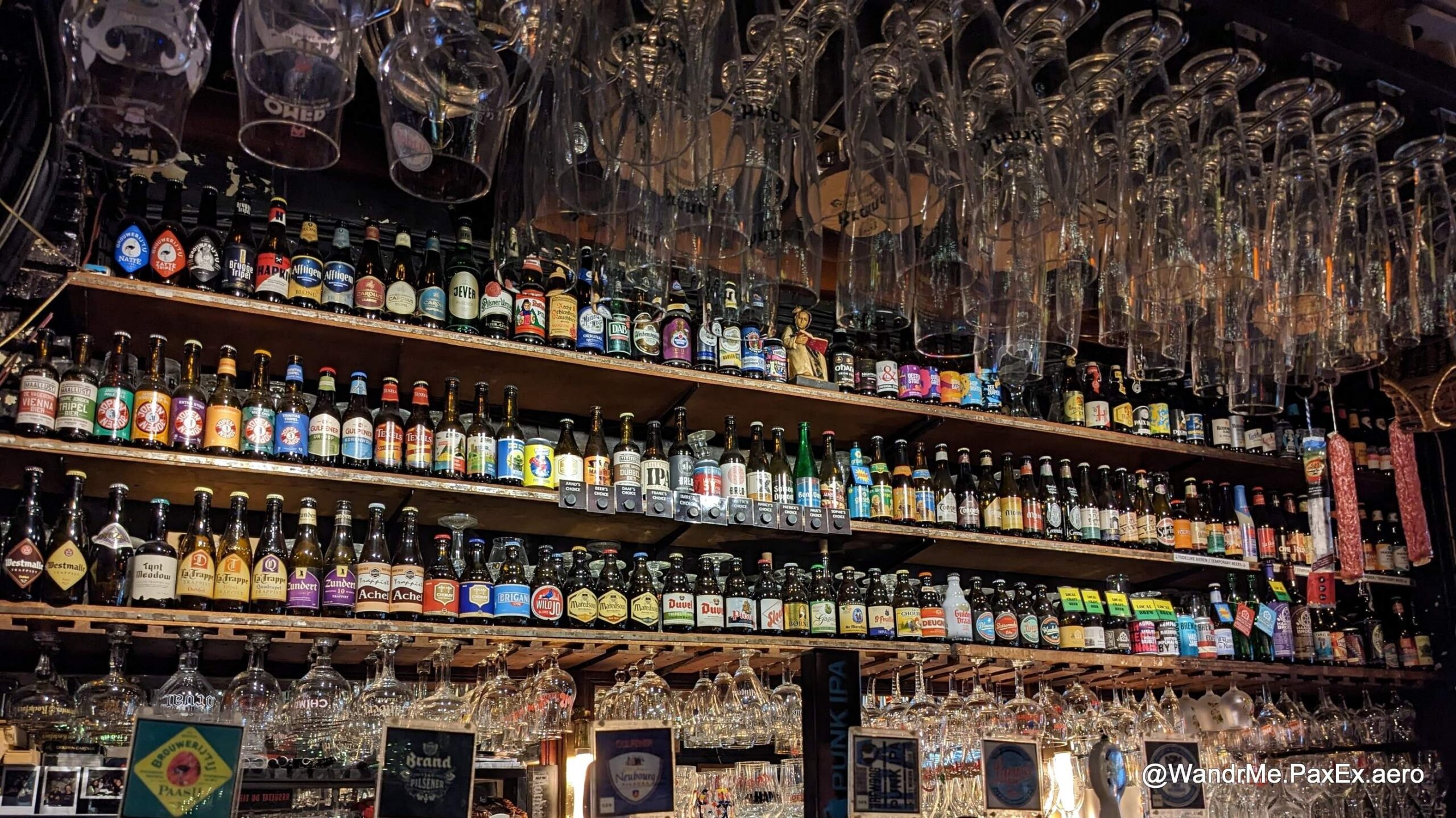 lots of beer bottles and glasses at a bar in the Netherlands