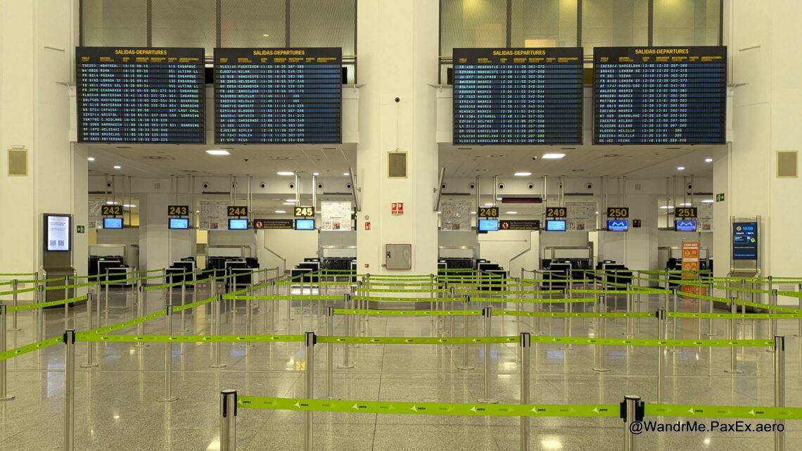 flights status boards over the check-in counters at an empty airport.
