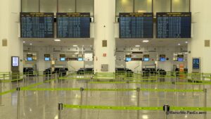 flights status boards over the check-in counters at an empty airport.