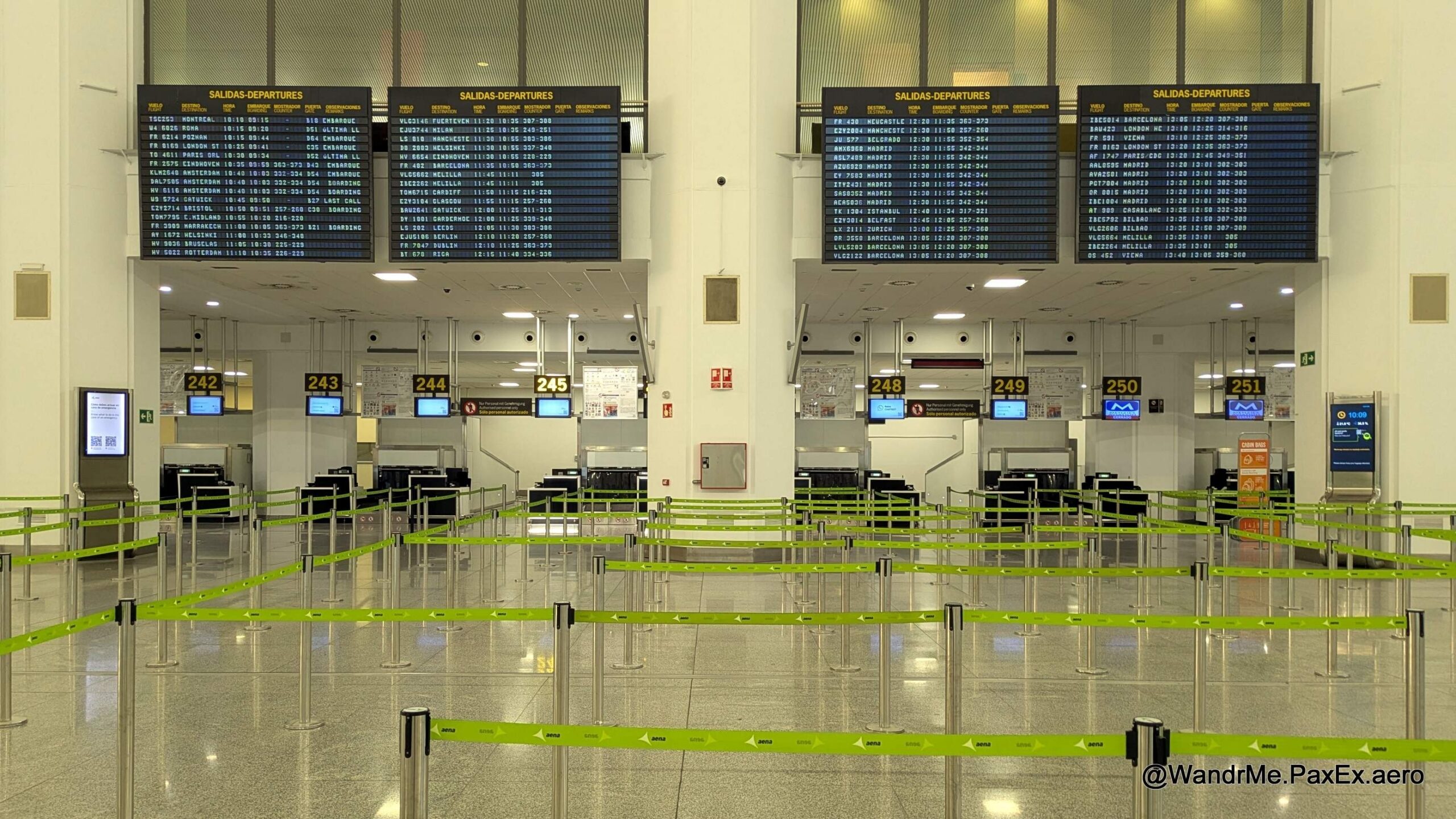 flights status boards over the check-in counters at an empty airport.