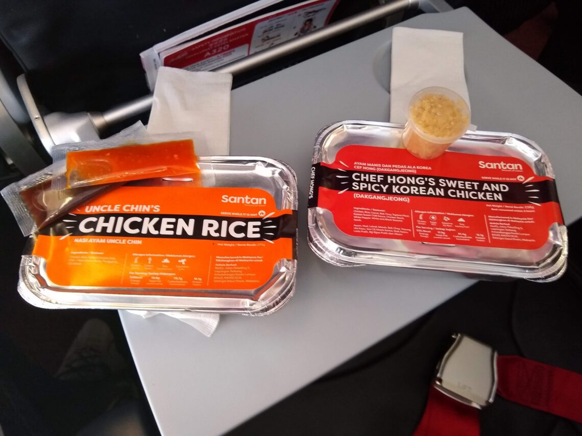 pair of inflight meals packed in foil trays on a tray table