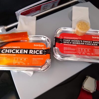 pair of inflight meals packed in foil trays on a tray table
