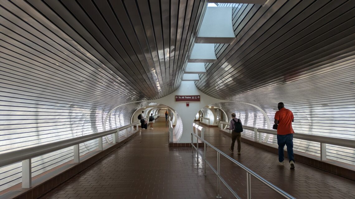 silver ceiling and walls in a train station tunnel