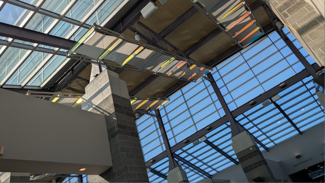 Interior of an airport, looking up at skylights.